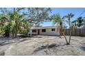 Inviting single-story home showcasing lush palm trees, a covered carport, and a freshly painted exterior at 514 Ralph St, Sarasota, FL 34242