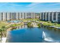 Beautiful condo community featuring lush landscaping, a serene lake with a fountain and a sparkling blue pool at 5780 Midnight Pass Rd # 210, Sarasota, FL 34242