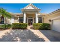 Elegant entrance featuring stately columns, manicured hedges, and a double-door entry at 7015 Stanhope Pl, University Park, FL 34201