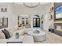 Bright living room with modern furniture, fireplace, decor shelves, and views of the entryway at 7024 Brier Creek Ct, Lakewood Ranch, FL 34202