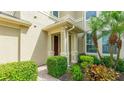 Inviting entryway with a brick path, lush shrubs, and covered porch at 8043 St Simons St, Bradenton, FL 34201