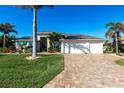 Spacious home with a three-car garage, brick-paved driveway, and lush landscaping at 9332 Miami Cir, Port Charlotte, FL 33981
