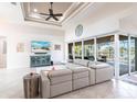 Spacious living room with tile floors, high ceilings, comfortable seating, and sliding glass doors to the lanai at 9332 Miami Cir, Port Charlotte, FL 33981