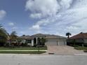 Charming single-story home featuring a well-manicured lawn, mature landscaping and a brick driveway at 10509 Winding Stream Way, Bradenton, FL 34212
