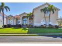 Stunning two-story home with lush landscaping, well-manicured lawn, grand double-door entry, and beautiful arched windows at 12622 Safe Harbour Dr, Cortez, FL 34215