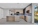 Modern kitchen with stainless steel appliances and bright wood cabinets, and island with seating at 1313 Kacerik St, North Port, FL 34288