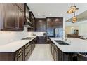 Modern kitchen with stainless steel appliances, white countertops, backsplash, and ample dark wood cabinetry at 13630 Deep Blue Pl, Bradenton, FL 34211