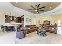 Spacious living room features elegant tray ceilings, neutral paint, and flows into the kitchen and dining area at 13630 Deep Blue Pl, Bradenton, FL 34211