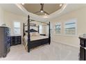 Inviting main bedroom with a tray ceiling, large windows with shutters, and neutral paint at 13630 Deep Blue Pl, Bradenton, FL 34211