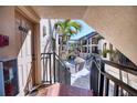 Inviting entryway to unit 603, with a glimpse of the well-maintained courtyard, lush palms, and community pool at 1760 Gulf Blvd # 603, Englewood, FL 34223