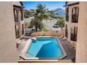Community pool surrounded by lounge chairs in tropical outdoor area at 1760 Gulf Blvd # 603, Englewood, FL 34223