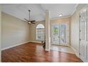 Living room with wood floors, ceiling fan, large windows, and a decorative column at 2260 Island Creek Rd, Sarasota, FL 34240