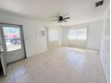 Bright living room featuring neutral walls, tile flooring, and a ceiling fan at 3035 Pershing Ave, Sarasota, FL 34234