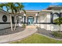 Welcoming front entrance featuring a blue double-door and professionally landscaped walkway at 360 Capri Isles Ct, Punta Gorda, FL 33950