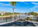 Hot tub overlooking a waterfront with boats, lush palm trees, and clear blue skies perfect for outdoor relaxation at 360 Capri Isles Ct, Punta Gorda, FL 33950
