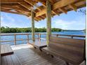 Scenic waterfront dock features benches and a covered area, providing a relaxing view of the water and lush greenery at 4920 Kestral Park Cir # 11, Sarasota, FL 34231