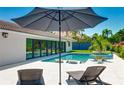 Beautiful backyard with a refreshing pool, spa, ample seating, and a lush tropical landscape for ultimate relaxation at 526 Bird Key Dr, Sarasota, FL 34236