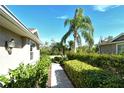 A stone path leads through lush greenery, providing a tranquil and inviting entrance to the home at 5283 Chase Oaks Dr, Sarasota, FL 34241