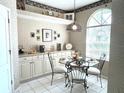 Cozy breakfast nook with a glass top table, bright window and built in cabinets at 5712 Cottonwood St, Bradenton, FL 34203