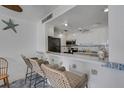 Kitchen bar that opens up into the main kitchen with white cabinetry and appliances at 7000 Beach Plz # 905, St Pete Beach, FL 33706