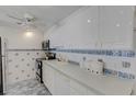 Kitchen with white cabinetry, light countertops, and tile backsplash at 7000 Beach Plz # 905, St Pete Beach, FL 33706