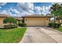 Single-story home featuring a two-car garage, well-maintained lawn, and manicured shrubbery at 7123 Heron Dr, Sarasota, FL 34243