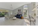 Bright living room featuring tile floors, high ceilings, fan, and a large window at 7123 Heron Dr, Sarasota, FL 34243