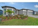 Up close view of the front of the house with manicured flower beds, stone walkway and bay windows at 9028 Sunray Cv, Parrish, FL 34219