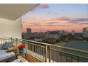 Condo balcony view overlooking the city with a table, chairs, and vibrant sunset at 100 Central Ave # F912, Sarasota, FL 34236