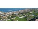 Expansive aerial view of a waterfront community with a golf course, bay, and nearby city skyline at 1050 Longboat Club Rd # 704, Longboat Key, FL 34228