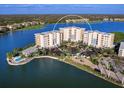 Aerial view of condo building surrounded by water with a pool, parking, and manicured landscaping at 10520 Boardwalk Loop # 205, Lakewood Ranch, FL 34202