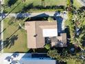Aerial view of home with a brown roof, patio area, driveway, and lush landscaping, offering a private and serene setting at 1103 Palma Sola Blvd, Bradenton, FL 34209