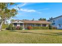Charming single-story home with a well-kept lawn and neat landscaping, featuring a classic design under a bright blue sky at 1103 Palma Sola Blvd, Bradenton, FL 34209