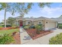 Charming single-story home with a beautifully landscaped front yard and inviting red front door at 11910 Soft Rush Ter, Lakewood Ranch, FL 34202