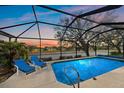 Relaxing screened-in pool area with a picturesque sunset view and comfortable lounge chairs at 11910 Soft Rush Ter, Lakewood Ranch, FL 34202