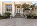 Inviting entryway with a paved walkway, decorative railings, and a covered porch with large glass paneled doors at 121 N Boulevard Of Presidents, Sarasota, FL 34236