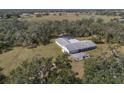 Aerial view of a home nestled on a large lot, featuring a pool, driveway, and abundant trees at 1510 Lena Ln, Sarasota, FL 34240