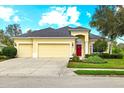 Charming single Gathering home with a three car garage, well manicured lawn and a welcoming red front door at 16422 Rivers Reach Blvd, Parrish, FL 34219