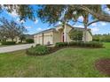 A cozy single Gathering home featuring an attached three car garage and verdant landscaping surrounding the property at 16422 Rivers Reach Blvd, Parrish, FL 34219