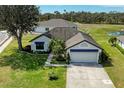 Aerial view of a well-kept home with blue awnings, beautiful landscaping, and a spacious front yard at 279 Park Forest Blvd, Englewood, FL 34223