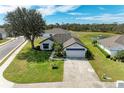 Aerial view of a house featuring an attached garage, a nearby pond, and neatly kept landscaping at 279 Park Forest Blvd, Englewood, FL 34223