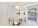 Bright dining area featuring modern lighting, a stylish round table, and sliding glass doors overlooking the pool area at 329 Avenida Leona, Sarasota, FL 34242