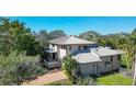 Two-story home with a metal roof, covered balcony, well-kept lawn, and mature trees at 4003 Bayside Dr, Bradenton, FL 34210