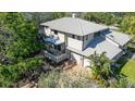 Two-story home featuring a metal roof, covered balcony, two-car garage, and well-maintained landscaping at 4003 Bayside Dr, Bradenton, FL 34210