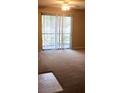 Carpeted living room with a sliding glass door leading to a balcony at 4008 Crockers Lake Blvd # 11, Sarasota, FL 34238