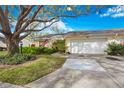 Inviting single-story home with a spacious driveway, attached garage, lush landscaping, and a welcoming entrance at 4050 Oakhurst Dr # 3175, Sarasota, FL 34233