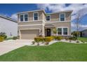 Inviting two-story home with a lush lawn, mature landscaping, and a welcoming front entrance at 411 158Th E St, Bradenton, FL 34212