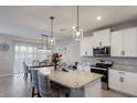 Modern kitchen with granite countertops, stainless steel appliances, and stylish pendant lighting at 411 158Th E St, Bradenton, FL 34212