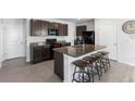 Open kitchen with a large island, granite countertops, dark cabinetry, and bar stool seating at 4205 Willow Hammock Dr, Palmetto, FL 34221