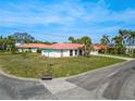 Street view of single-story home with a red tile roof, palm trees, and green lawn at 441 Rubens E Dr, Nokomis, FL 34275
